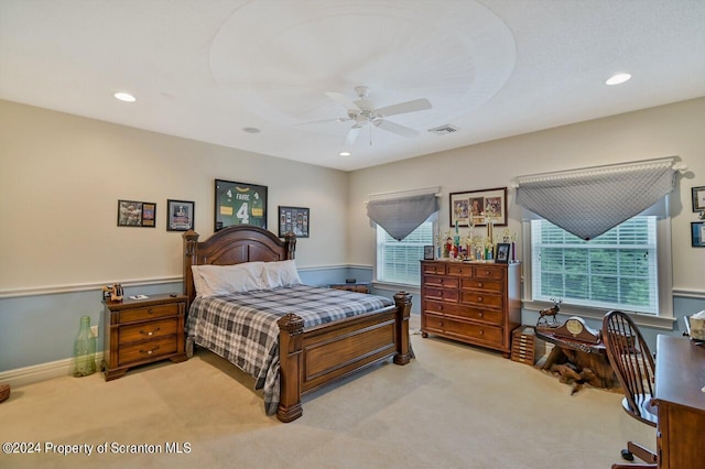 carpeted bedroom featuring multiple windows and ceiling fan