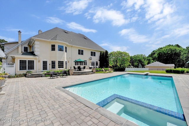 view of swimming pool featuring an in ground hot tub and a patio