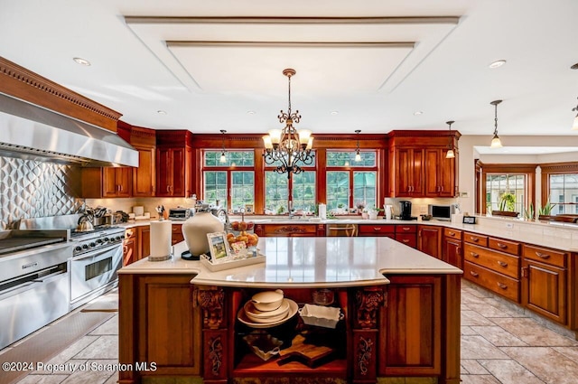 kitchen featuring a center island, stainless steel appliances, hanging light fixtures, and a notable chandelier