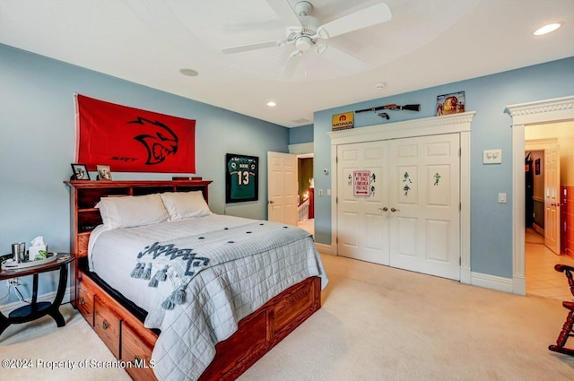 carpeted bedroom with ceiling fan and a closet