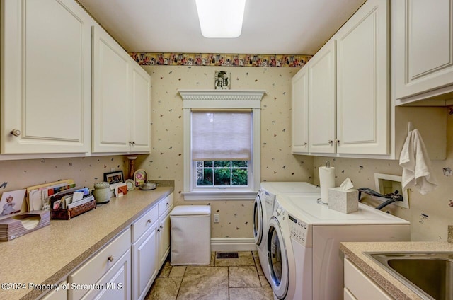 clothes washing area with washer and dryer and cabinets