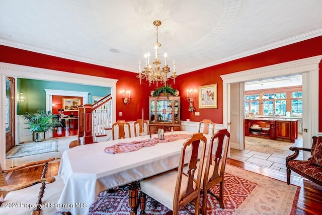 dining space featuring light hardwood / wood-style floors, ornamental molding, and a chandelier