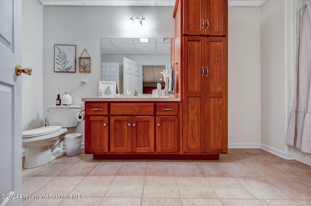 bathroom with tile patterned floors, a paneled ceiling, vanity, and toilet