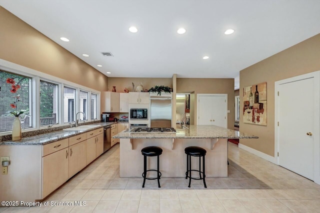 119 Glenmaura Dr, Moosic, PA 18507 - kitchen featuring built in appliances, a center island, light tile patterned flooring, light stone countertops, and a breakfast bar