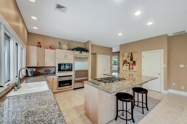 119 Glenmaura Dr, Moosic, PA 18507 - kitchen featuring built in appliances, a kitchen island, light tile patterned floors, a breakfast bar, and recessed lighting