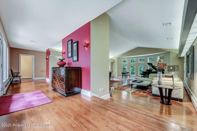 119 Glenmaura Dr, Moosic, PA 18507 - living area featuring wood finished floors, vaulted ceiling, and a baseboard heating unit
