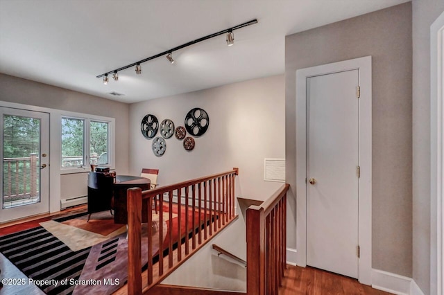 119 Glenmaura Dr, Moosic, PA 18507 - staircase featuring track lighting, wood finished floors, and a baseboard heating unit