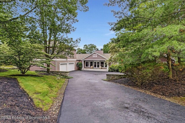 119 Glenmaura Dr, Moosic, PA 18507 - view of front facade featuring driveway, stucco siding, a garage, and a chimney