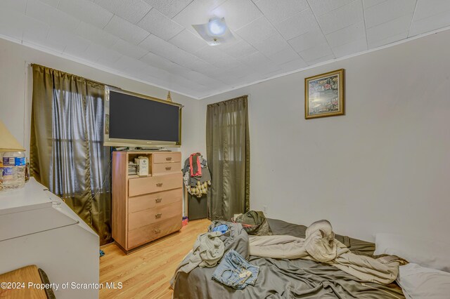 bedroom with hardwood / wood-style floors and ornamental molding