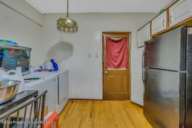 clothes washing area featuring independent washer and dryer and light hardwood / wood-style flooring