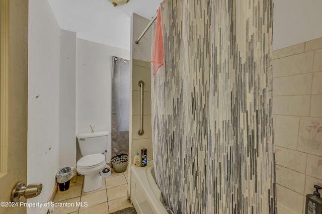 bathroom featuring tile patterned flooring, toilet, shower / washtub combination, and tile walls