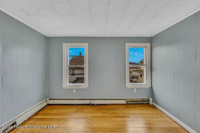 unfurnished room with light hardwood / wood-style flooring and a baseboard radiator