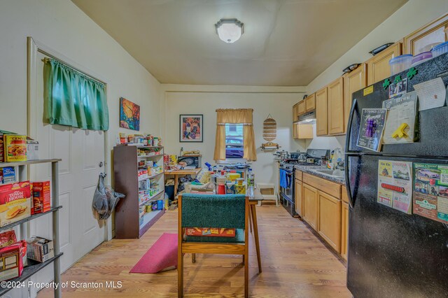 kitchen with black appliances, light wood-type flooring, and light brown cabinetry