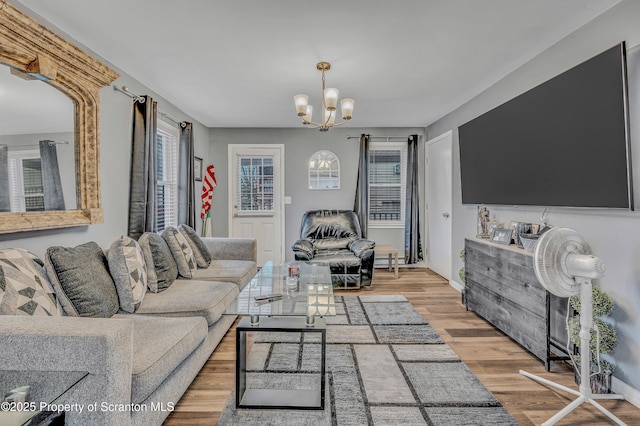 living room featuring a notable chandelier and light hardwood / wood-style flooring