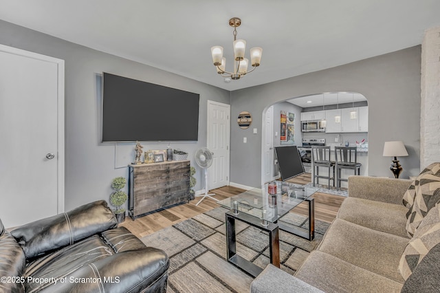 living room with an inviting chandelier and light hardwood / wood-style floors