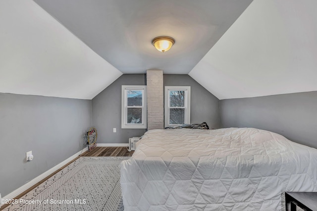 bedroom with hardwood / wood-style flooring and lofted ceiling