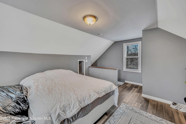 bedroom featuring lofted ceiling and hardwood / wood-style floors