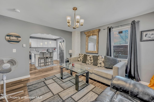 living room with an inviting chandelier and light hardwood / wood-style floors