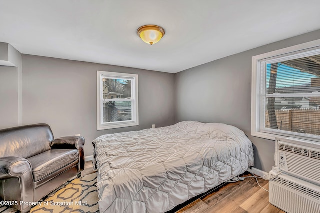 bedroom featuring multiple windows and light hardwood / wood-style flooring