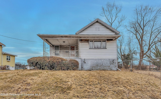 view of front of house with covered porch, fence, and a front lawn