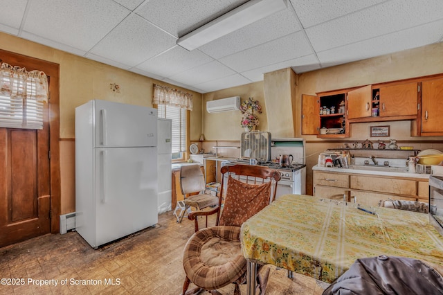 kitchen featuring a wall unit AC, a baseboard radiator, light countertops, white appliances, and a drop ceiling