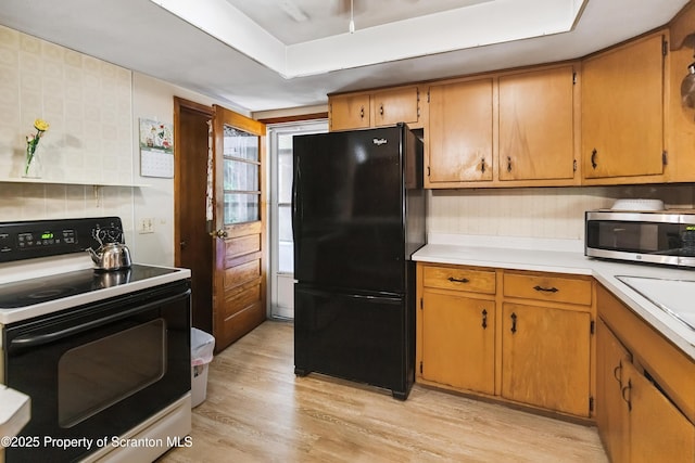 2807 S Webster Ave, Scranton, PA 18505 - kitchen with freestanding refrigerator, range with electric stovetop, stainless steel microwave, light countertops, and light wood finished floors