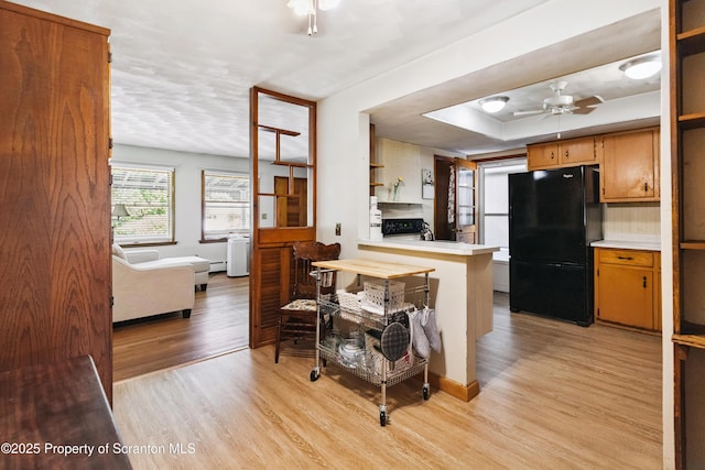 2807 S Webster Ave, Scranton, PA 18505 - kitchen with freestanding refrigerator, light wood-style floors, light countertops, a peninsula, and a ceiling fan