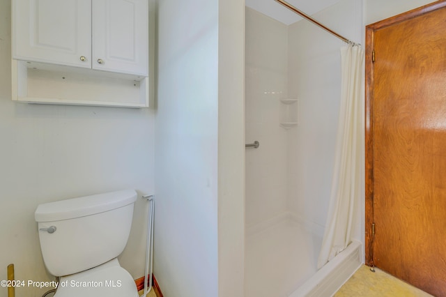 bathroom with a shower with curtain and toilet