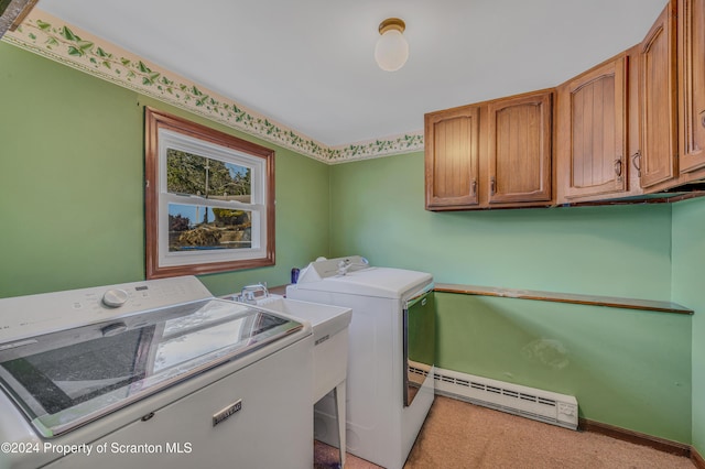 clothes washing area with cabinets, washing machine and dryer, and baseboard heating