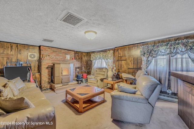 carpeted living room with a healthy amount of sunlight, a textured ceiling, baseboard heating, and wooden walls