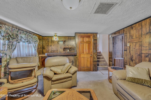 carpeted living room featuring a textured ceiling and wooden walls