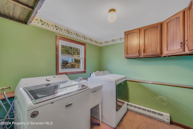 laundry area with sink, cabinets, baseboard heating, and washing machine and clothes dryer