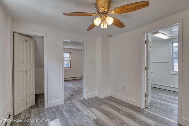 326 Neptune Pl, Scranton, PA 18505 - unfurnished bedroom featuring a baseboard radiator, baseboard heating, wood finished floors, and a spacious closet