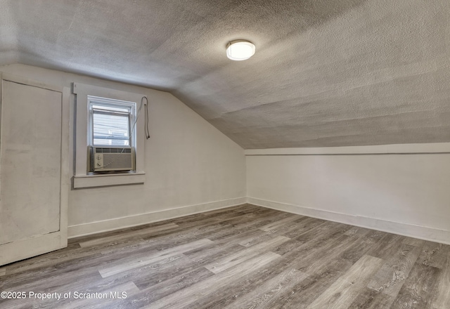 326 Neptune Pl, Scranton, PA 18505 - additional living space with cooling unit, a textured ceiling, wood finished floors, and vaulted ceiling
