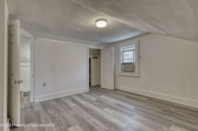326 Neptune Pl, Scranton, PA 18505 - unfurnished bedroom featuring a textured ceiling, wood finished floors, cooling unit, and vaulted ceiling