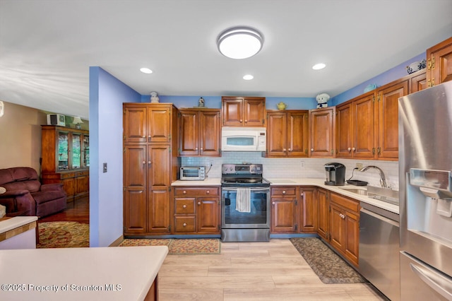 592 Gravel Pond Rd, Clarks Summit, PA 18411 - kitchen featuring appliances with stainless steel finishes, light wood-type flooring, light countertops, brown cabinetry, and recessed lighting