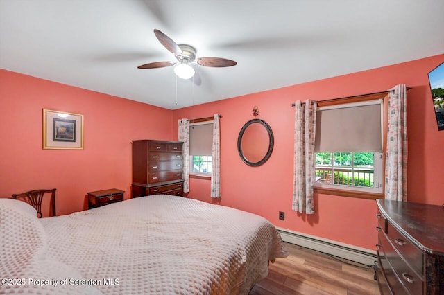 592 Gravel Pond Rd, Clarks Summit, PA 18411 - bedroom with baseboard heating, wood finished floors, multiple windows, and a ceiling fan