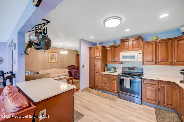 592 Gravel Pond Rd, Clarks Summit, PA 18411 - kitchen with stainless steel range with electric cooktop, white microwave, brown cabinets, light countertops, and recessed lighting