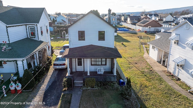 exterior space featuring covered porch and a front lawn