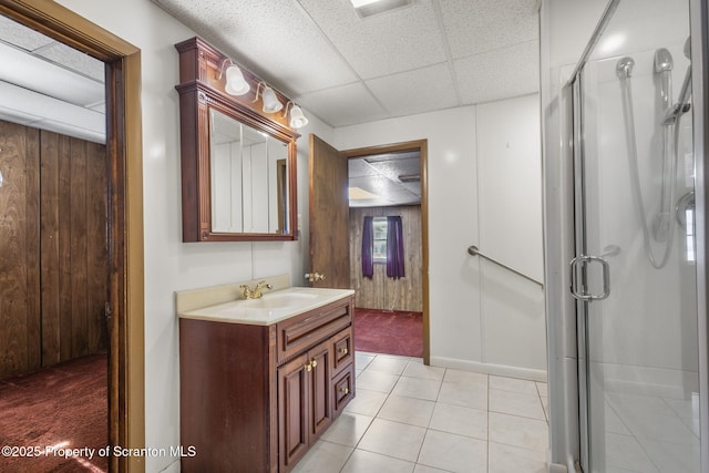 full bath featuring a drop ceiling, wooden walls, and a shower stall