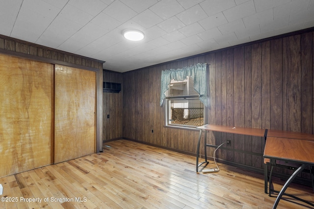 unfurnished bedroom featuring wood walls and light wood-style floors