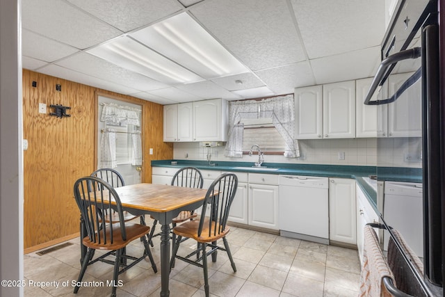 kitchen with white cabinetry, visible vents, white dishwasher, and a sink