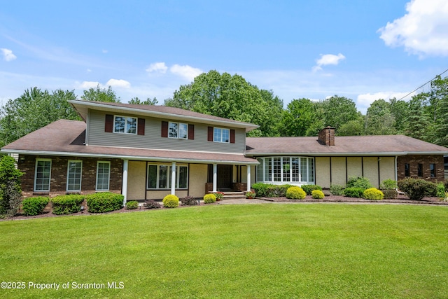 73 Quinton Rd, Scott Twp, PA 18447 - view of front facade with a front yard, a porch, a chimney, and brick siding