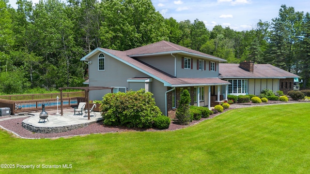 73 Quinton Rd, Scott Twp, PA 18447 - back of property with a patio, a chimney, roof with shingles, and a wooded view