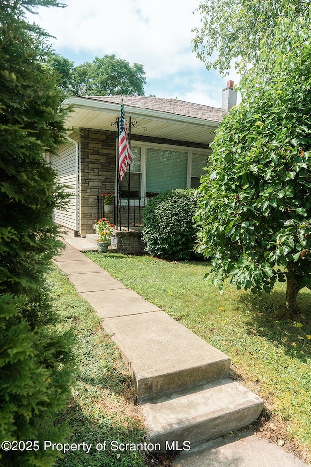 118 Howard St, Old Forge, PA 18518 - view of front of house with stone siding, a chimney, a front lawn, and a porch