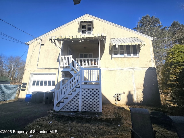 view of front of property featuring stucco siding, a garage, and stairway