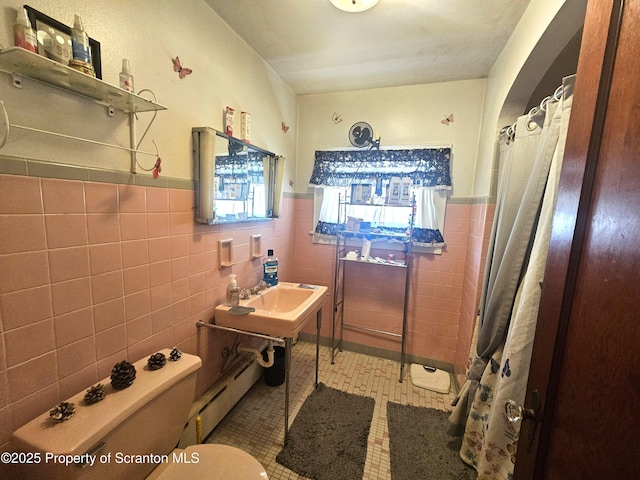 full bath with toilet, a shower with shower curtain, tile walls, tile patterned flooring, and baseboard heating