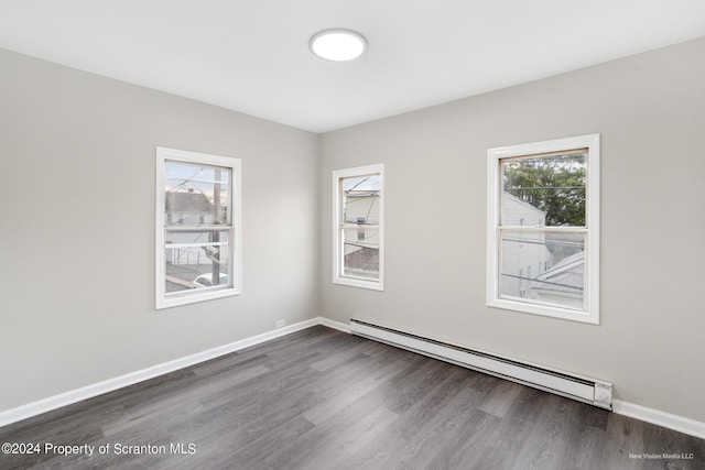 empty room featuring dark hardwood / wood-style flooring and baseboard heating