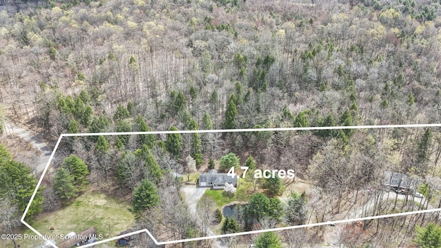 bird's eye view with a wooded view