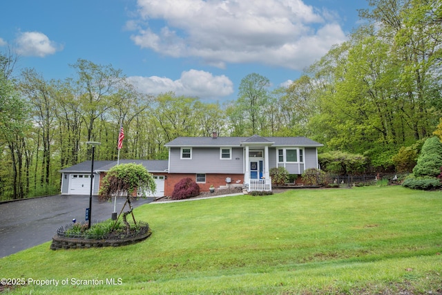 210 Willow Dr, Jefferson Twp, PA 18436 - raised ranch with a garage, driveway, brick siding, a chimney, and a front yard